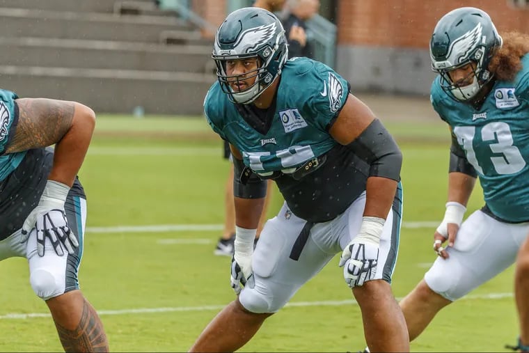 Eagles offensive lineman, #72, Halapoulivaati Vaitai, center, stretches during warm ups, before Sunday's practice, in the rain, at the NovaCare Center. MICHAEL BRYANT / Staff Photographer