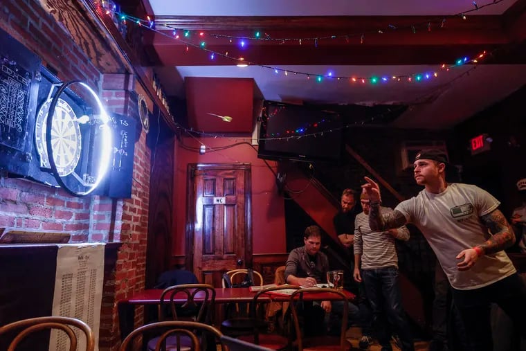 The Bonnie Situation’s Jesse Cantz throws against the Artful Dodgers in the Olde English Dart League at the Taproom on 19th in South Philadelphia.