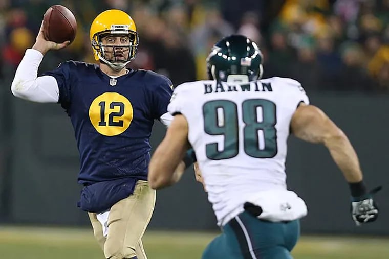 Packers quarterback Aaron Rodgers looks to pass as Connor Barwin, chases him down. (David Maialetti/Staff Photographer)