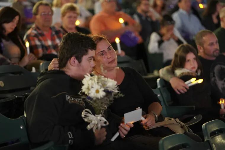 Kimberly Ruediger holds her son Gabriel Ruediger, as they participate during an October candlelight vigil at the Camden Waterfront Stadium in remembrance of those who have died from drug overdoses.