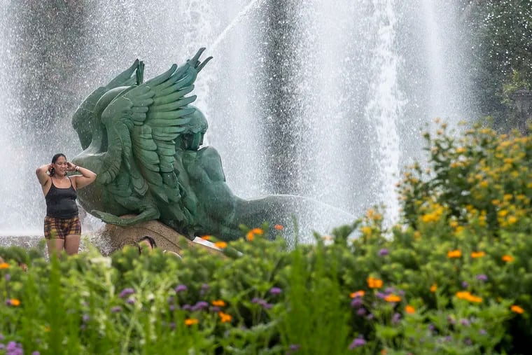 A woman cools off from the heat during the summer of 2022 at the Logan Circle fountains in Philadelphia.