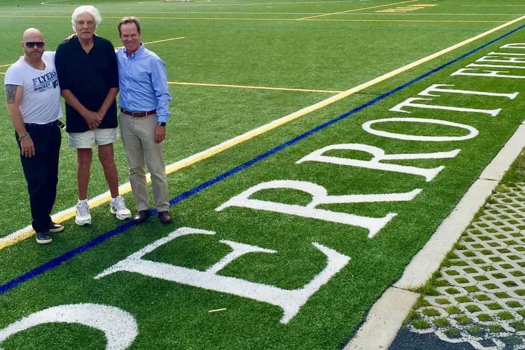 Mr. Perrott (center) stands on the field named for him with sons Keith (left) and Frank.