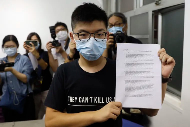 Hong Kong pro-democracy activist Joshua Wong shows a notice disqualifying him from running in legislative elections during a press conference on Friday.