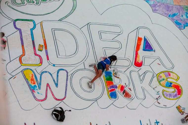 A young girl works at coloring in the R in IDEA WORKS. Approximately 25 students from Independence Charter School West in Philadelphia attempted to color this large drawing.