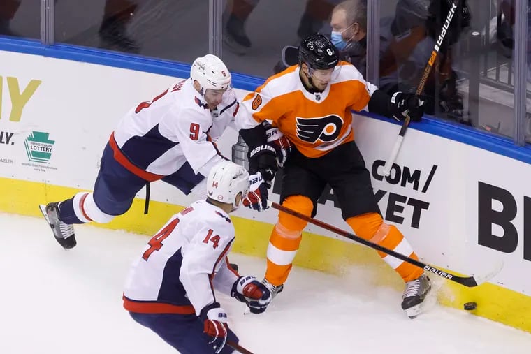 Capitals defenseman Dmitry Orlov (9) and Flyers defenseman Robert Hagg (8) vie for the puck in the corner during the second period.