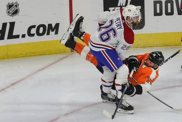 Sean Couturier gets upended by the Canadiens' Jeff Petry during the first period.