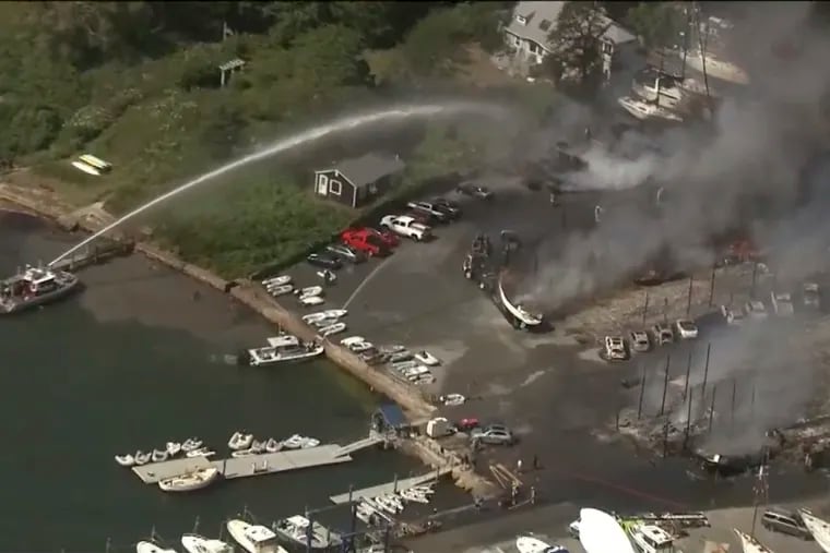 Crews battle a massive fire at a boat yard in Mattapoisett, Mass., on Friday.