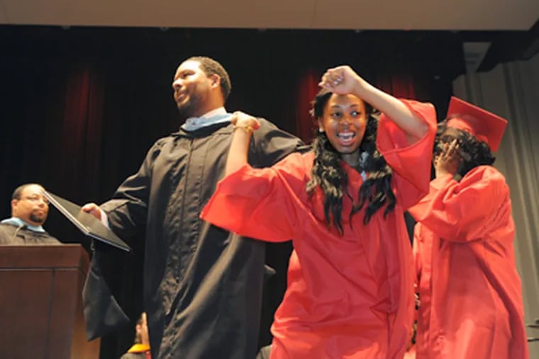 Malikah Jones does a graduation dance Tuesday during ceremonies at South Philadelphia High School as Principal Otis Hackney waits to award her a diploma. (April Saul / Staff Photographer)