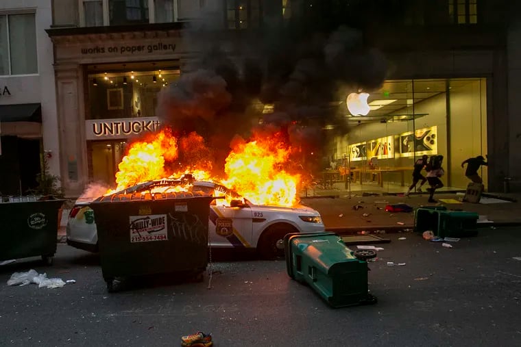 A Philadelphia Police car on fire in front of Apple store on Saturday, the first of several days of protests and looting across Philadelphia.