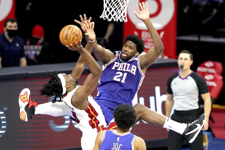 Joel Embiid, right, of the SIxers fouls Precious Achiuwa of the Heat during the 4th quarter of a NBA game at the Wells Fargo Center on Jan. 12, 2021.