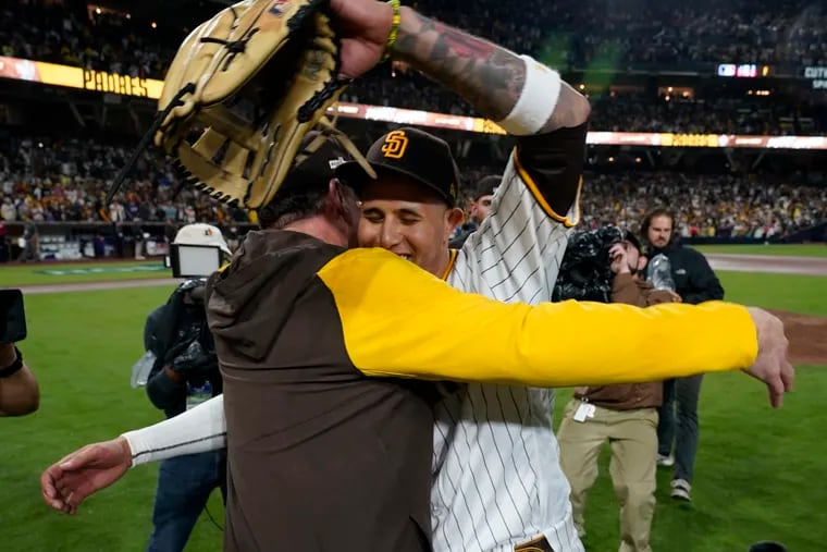 Manny Machado (right) embraces manager Bob Melvin after the Padres defeated the Dodgers, 5-3, in Game 4 on Saturday night.