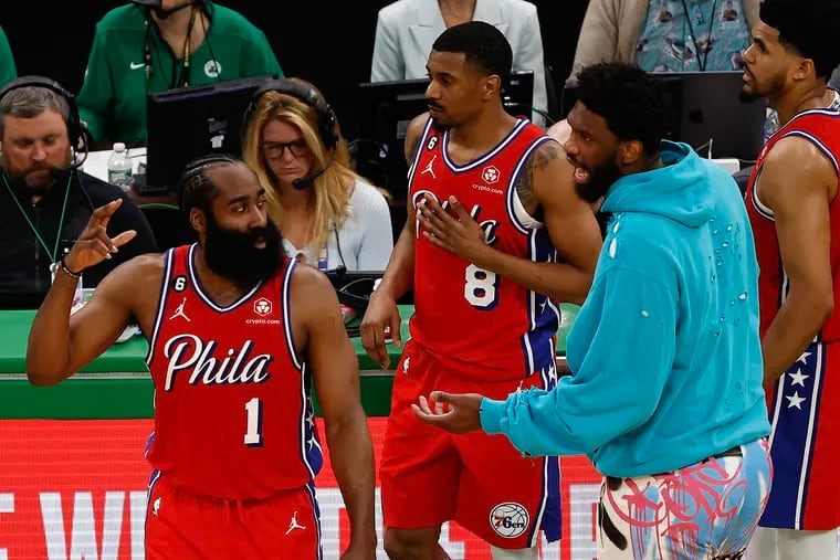 Injured Sixers center Joel Embiid talks to teammates James Harden, De'Anthony Melton and Tobias Harris during Game 1 of the Eastern Conference playoff semifinals at TD Garden in Boston on Monday, May 1, 2023.