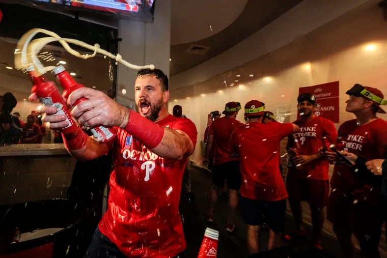 Kyle Schwarber sprays beer on his teammates after the Phillies clinched a wild-card playoff spot on Tuesday.