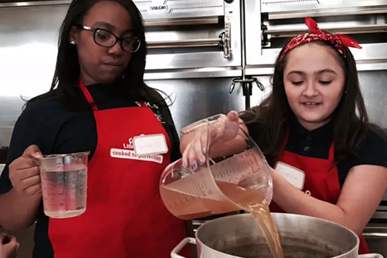 At Russell Byers Charter, Soonae Shuler (left) and Gianna Rosado pour chicken stock. (Photo credit: Cindy Rappoport)