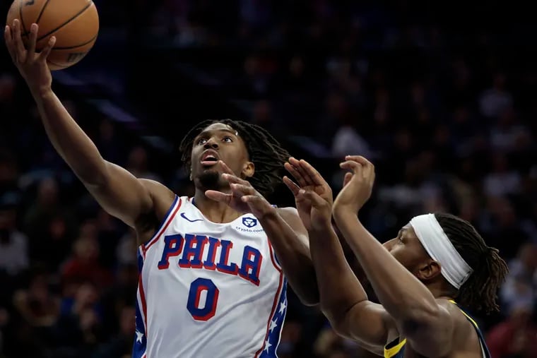 The Sixers' Tyrese Maxey lays up the basketball despite Pacers forward Myles Turner's attempt to block his shot.