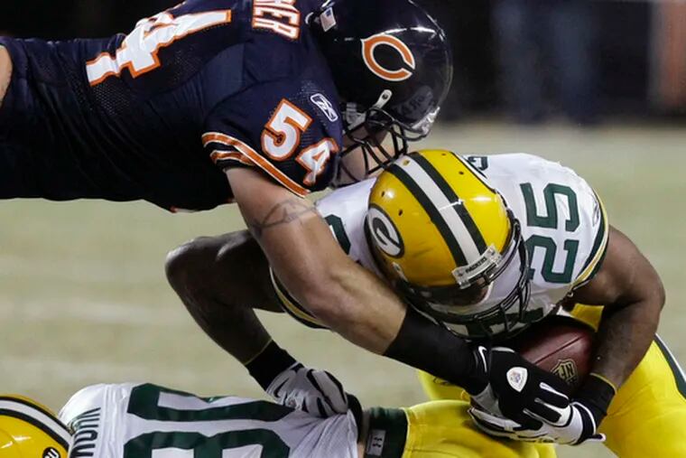 Chicago linebacker Brian Urlacher moves to tackle Green Bay running back John Kuhn. Last night&#0039;s game between the Bears and the Packers ended too late for this edition.