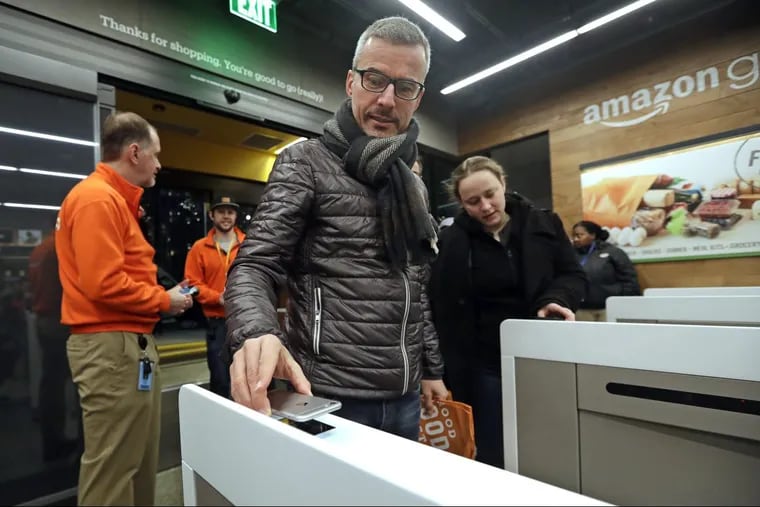 A customer scans his Amazon Go cellphone app at the entrance as he heads into an Amazon Go store in Seattle. The store, which opened to the public on Monday, allows shoppers to scan their smartphone with the Amazon Go app at a turnstile, pick out the items they want and leave. The online retail giant can tell what people have purchased and automatically charges their Amazon account.