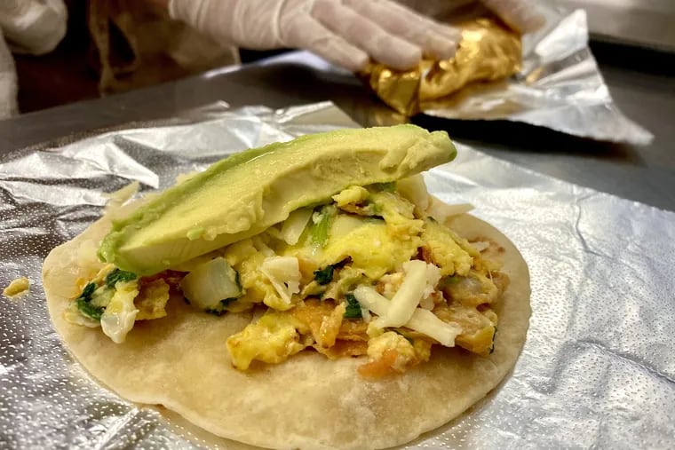 Nano Wheedan rolls up a breakfast taco. He makes tacos from his own flour tortillas.