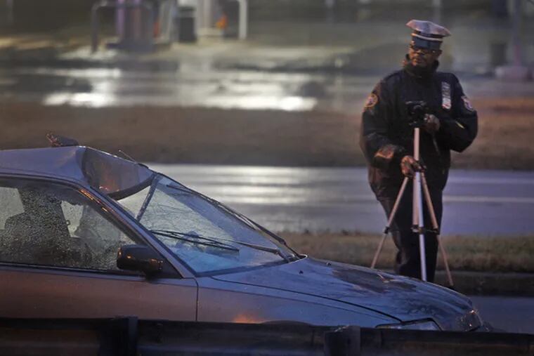 A police officer investigates damage to a car after a pedestrian was fatally struck on Roosevelt Boulevard near Welsh Road on the morning of Jan. 27, 2012.