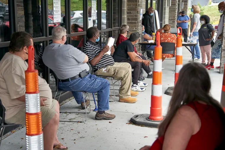 In this July 15 photo, job seekers exercised social distancing as they waited to be called into the Heartland Workforce Solutions office in Omaha, Neb.