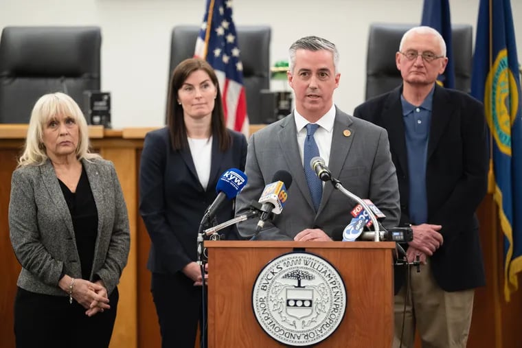 Bucks County Commissioner Vice Chair Bob Harvie speaking at a news conference on Monday to announce the county's lawsuit against several major oil companies. Also pictured are Commissioner Chair Diane Ellis-Marseglia (left), Bucks County Solicitor Amy Fitzpatrick (second to left), and Commissioner Gene DiGirolamo (right).