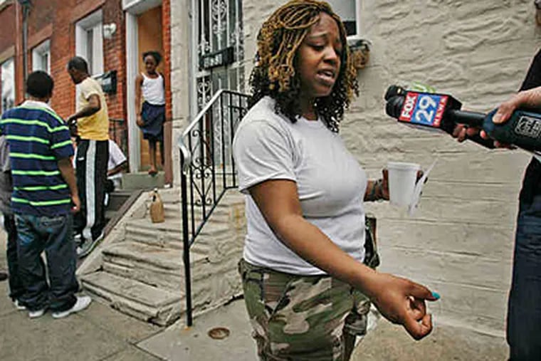 File photo: Shanae Williams demonstrates the way she says her estranged husband held a gun as he shot her brother, while children and adults were having a water fight in the 1800 block of Hoffman Street. (05/04/2010; Alejandro A. Alvarez/Staff)