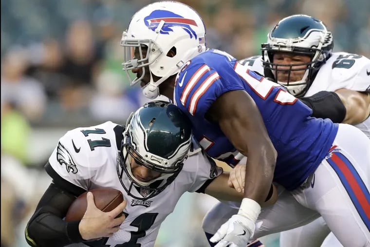 Buffalo defensive end Jerry Hughes sacks Carson Wentz in the first quarter. At right is left tackle Lane Johnson