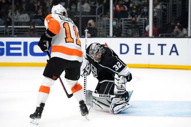 Los Angeles Kings goaltender Jonathan Quick (32) blocks a shot in front of Philadelphia Flyers right wing Travis Konecny (11) during the first period of an NHL hockey game Saturday, Jan. 1, 2022, in Los Angeles.