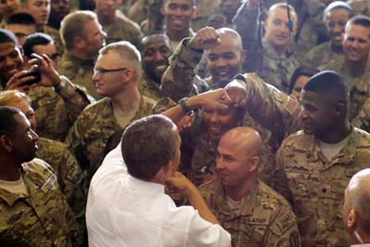 President Barack Obama fist bumps service members after he addressed troops at Bagram Air Field, Afghanistan, Wednesday, May 2, 2012. (AP Photo/Charles Dharapak)