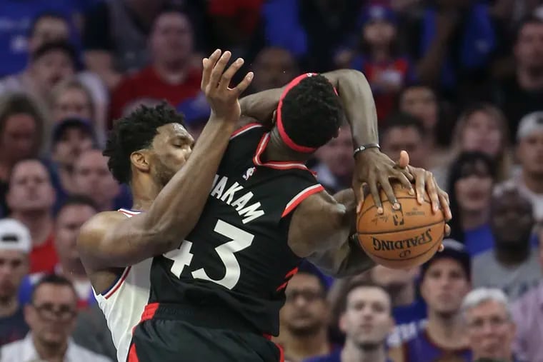 Sixers' Joel Embiid wraps up Raptors' Pascal Siakam during the 4th quarter of Game 3 of the second round of the NBA playoffs at the Wells Fargo Center in Philadelphia, Thursday, May 2, 2019. Sixers beat the Raptors 116-95.