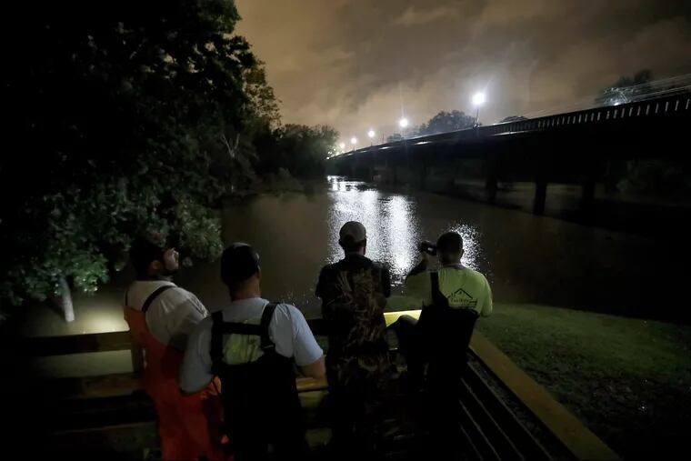 A group of local fishermen keep an eye on the Cape Fear River as they stage for potential water rescues while additional flooding remains a threat from Florence, in Fayetteville, N.C., Sunday, Sept. 16, 2018.