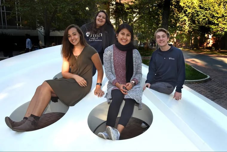 Clockwise from front, posing on the “Button”: sculpture are Daisy Angeles, Haley Carbajal, Carmen Duran, and Anthony Scarpone-Lambert, on the University of Pennsylvania campus. They are part of a group of students who are first-generation students.