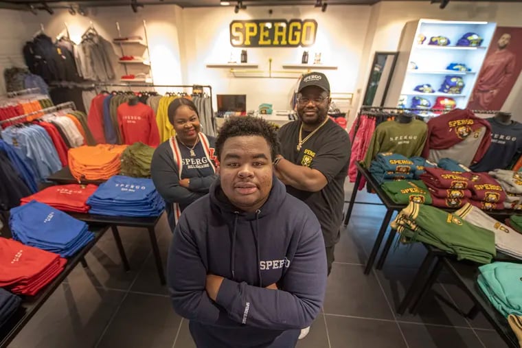 Trey Brown, center with his mother, Sherell Peterson and his grandfather, Steven Hite atthe  Spergo clothing store at the King of Prussia Mall. Trey, a 15-year-old African American cyber school student, runs the Spergo clothing product line and operates a King of Prussia store. He appeared on Shark Tank. His mother is a former Philadelphia school teacher.