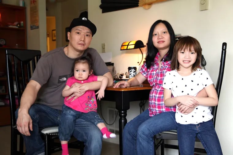Korean adoptee Adam Crapser, left, with daughters, Christal, 1, Christina, 5, and his wife, Anh Nguyen, in the family's living room in Vancouver, Wash. in 2015. Crapser, whose adoptive parents failed to make him a U.S. citizen, was deported to South Korea in 2016. 