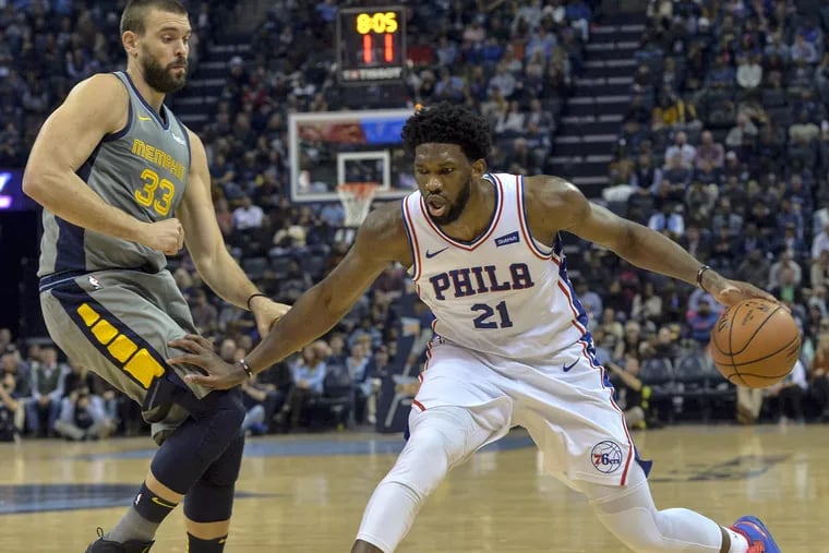 Sixers' center Joel Embiid (21) drives against Grizzlies center Marc Gasol on Saturday.