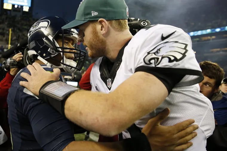 The QB who might have been and the QB who was: Russell Wilson, left, and Carson Wentz embrace after the Seahawks' 26-15 victory over the Eagles in 2016.