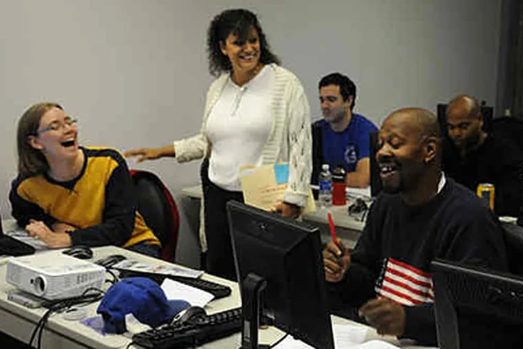 Betty Palmieri (center) talks with students Robin Amberson (left) of West Chester and Gary Pitman of Philadelphia at the tech academy at North Catholic. (Sarah J. Glover / Staff)