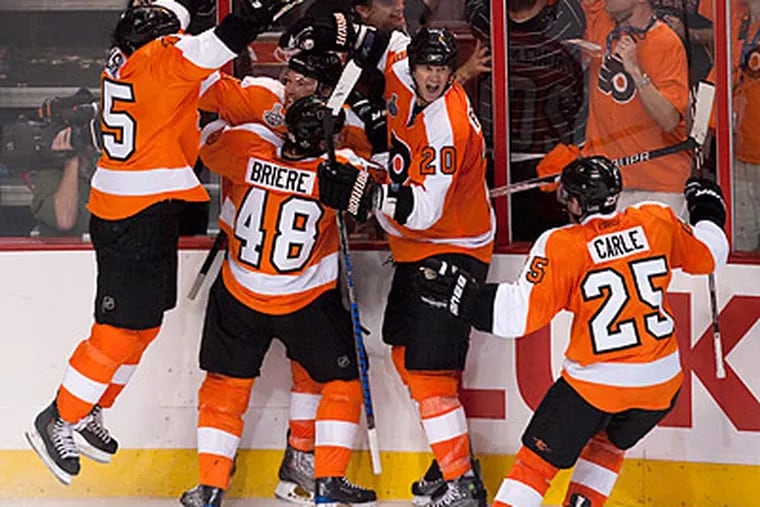 Flyers players celebrate Claude Giroux's game-winning goal in overtime. (Ed Hille/Staff Photographer)