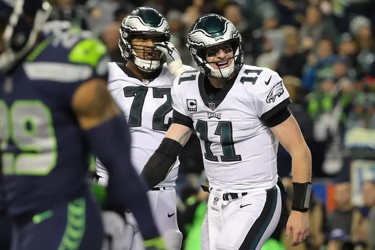 Eagles’ quarterback Carson Wentz, right, reacts after he fumbled the ball away against the Seahawks in the third quarter of the Birds’ loss.