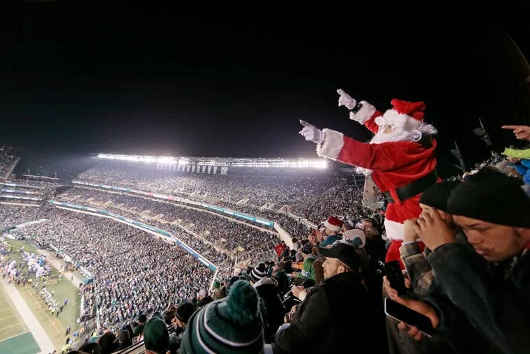 From upper level seats close to the North Pole, SANTA (Eric Halberstach of Philadelphia) signals another Eagle first down in the first half of the Dallas Cowboys vs. Philadelphia Eagles NFL football game at Lincoln Financial Field on Dec. 22, 2019.