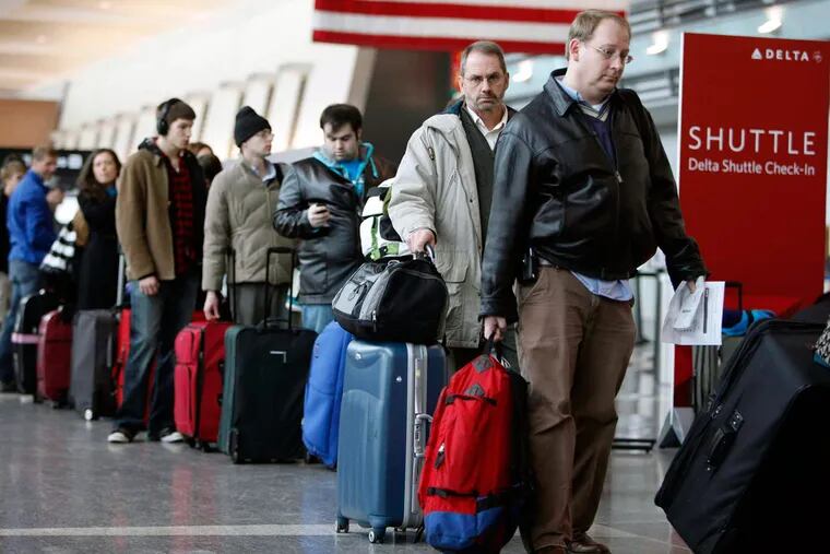In this Dec. 21, 2009, file photo, passengers wait to check in at Logan International Airport in Boston.