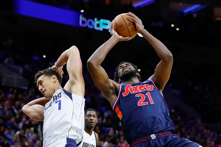 Sixers center Joel Embiid gets fouled shooting the basketball against Dallas Mavericks center Dwight Powell during the second quarter on Friday, March 18, 2022 in Philadelphia.