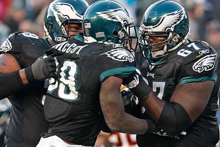 LeSean McCoy got a lift from Nick Cole (left) and Jamaal Jackson (right) after tying the game on a two-point conversion in the fourth quarter of the Eagles' 27-24 win over the Redskins. (Ron Cortes/Staff Photographer)