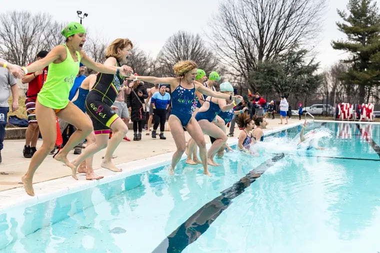 A group of women with Waves, a female athlete support group, jump together into the pool for the Philly Phreeze at the John Kelly Pool in Philadelphia on Saturday.