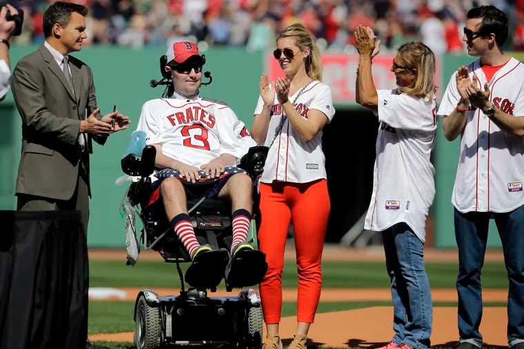 FILE - In this April 13, 2015, file photo, Pete Frates, former Boston College baseball player whose Ice Bucket Challenge raised millions for ALS research, is applauded by Boston Red Sox general manager Ben Cherington, far left, and his wife Julie Frates, center, along with other family members prior to the home opener baseball game between the Boston Red Sox and the Washington Nationals at Fenway Park in Boston. Frates, who was stricken with amyotrophic lateral sclerosis, or ALS, died Monday, Dec. 9, 2019. He was 34.