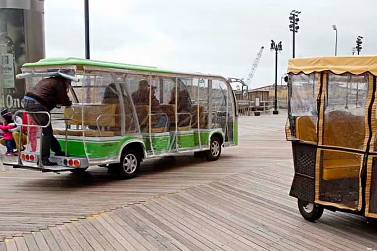 A Boardwalk Jitney is passing a traditional rolling cart. ( AKIRA SUWA  /  Staff Photographer )