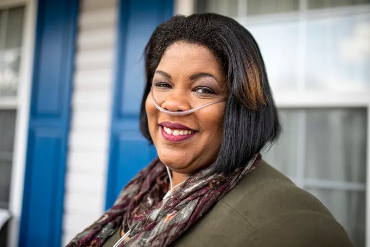 Joy Ezekiel-Gibson, 47, poses at her home in Atco, NJ.  Joy got COVID-19 in mid-March 2020.  She was hospitalized for 30 days, home for 8 days and back in the hospital for 12 more days with pneumonia and blood clots. She has been on oxygen at home since May of 2020. “I was hoping to get off the oxygen, but unfortunately my lungs were too damaged,” Joy said. “I used to regret it but now it's my new normal. They help me to breathe and I have little more independence when I came home. I’m grateful, I’m truly, truly grateful.”