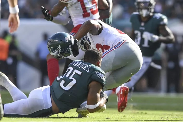 Eagles linebacker Mychal Kendricks loses his helmet as he tackles Giants running back Paul Perkins.