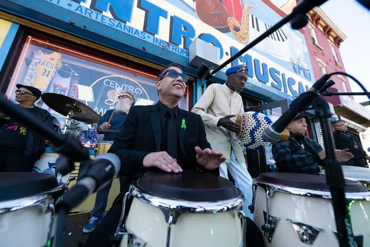 Pablo Batista (center), Robert Kenyatta (right), and Mickey Rivera (far right), along with others, play music in tribute to Jesse Bermudez on Wednesday morning.