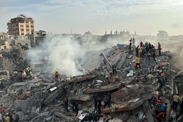 Palestinians look for survivors following Israeli airstrike in Nusseirat refugee camp in the Gaza Strip on Oct. 31. On April 4, Human Rights Watch says an Israeli attack on a Gaza apartment building in October killed at least 106 civilians, including 54 children.